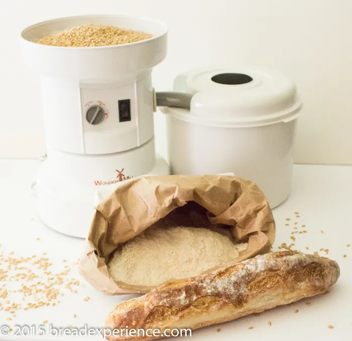 WonderMill Grain Mill with grains milled into flour and baguette